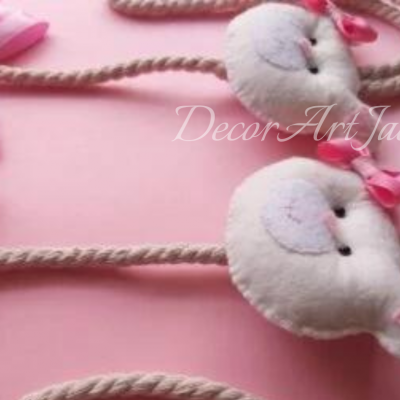 Pendentes de pelúcia em forma de cabeça de animal com laços rosas sobre fundo rosa