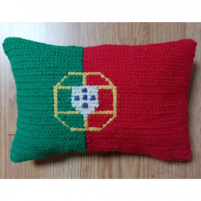Almofada tricotada verde e vermelha com brasão ao centro