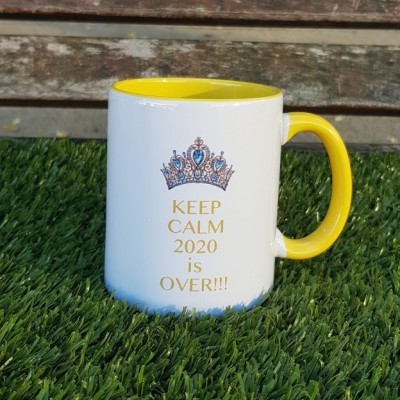 Caneca branca amarelo interior com texto KEEP CALM 2020 is OVER e coroa azul dourada