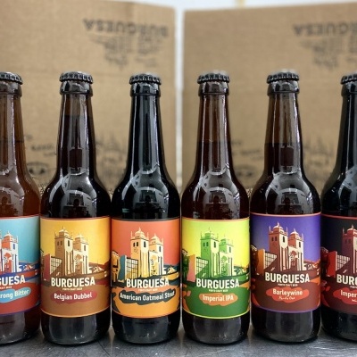 Seis garrafas de cerveja artesanal Burquesa com rótulos coloridos em fila.