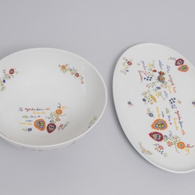 Dois pratos brancos decorados com flores, corações e texto colorido