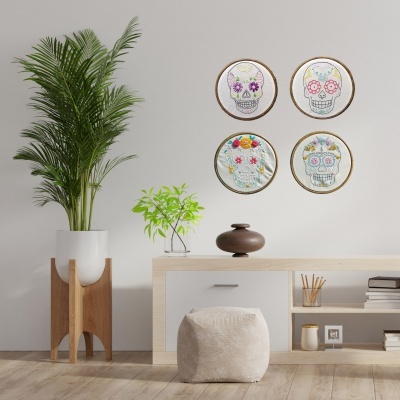 Sala moderna com parede cinza claro, plantas em vasos e quatro bordados redondos de caveiras coloridas