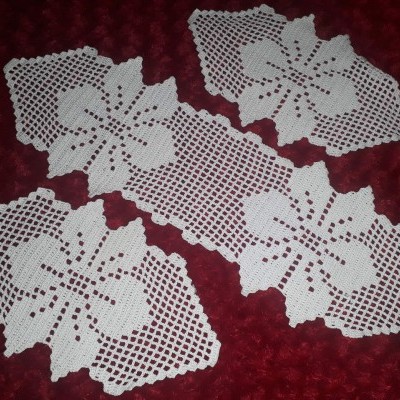 Toalhitas de crochet brancas com padrão de flores sobre fundo vermelho