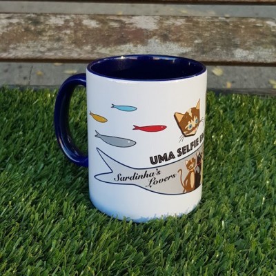 Caneca branca e azul com ilustrações de peixes e gatos em relvado