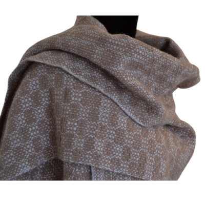 Manta castanha com padrão branco num manequim preto