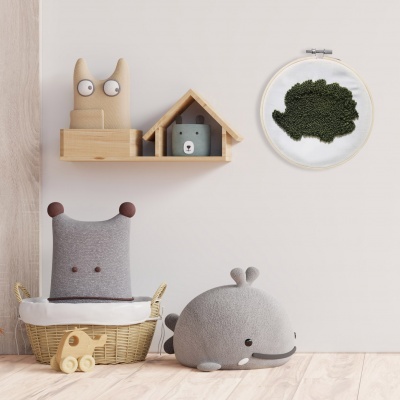 Brinquedos e decoração infantil com pelúcias e moldura de musgo na parede