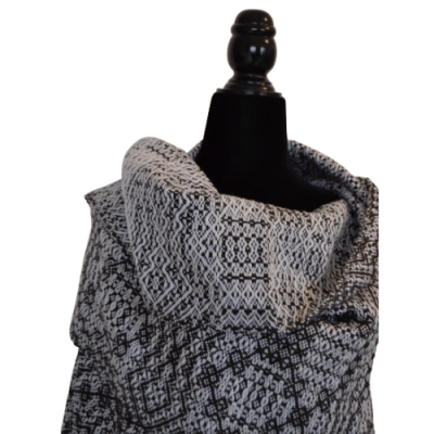 Xale preto e branco com padrão geométrico num manequim preto