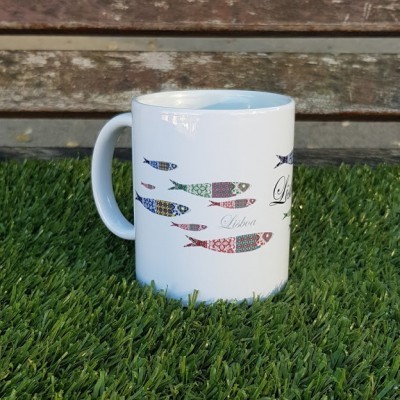 Caneca branca com peixes coloridos e texto Lisboa em relva