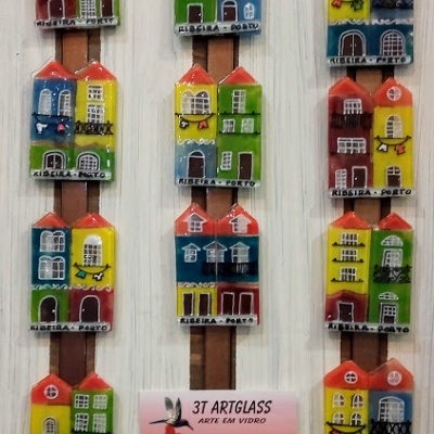 Ímanes de vidro de casas coloridas com inscrição RIBEIRA - PORTO expostos em placa de madeira