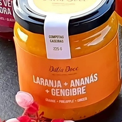Frasco de compota de laranja, ananás e gengibre da Dália Doce com etiquetas e flores ao lado
