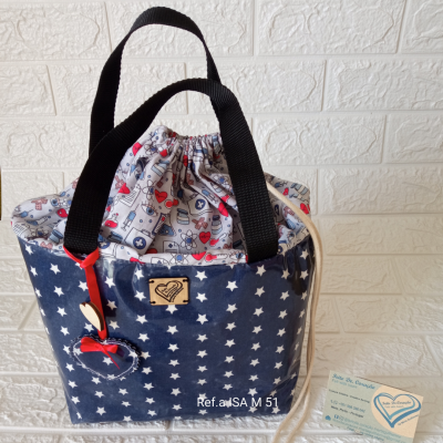 Bolsa azul com estrelas brancas, alças pretas e pendente de coração