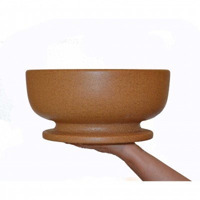 Tigela castanha cerâmica fosca sobre mão com fundo branco