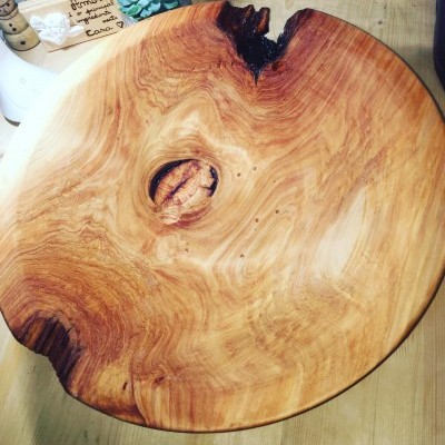 Prato ou tábua de madeira natural redonda com veios e nó escuro