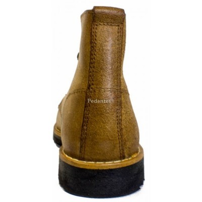 Bota de camurça castanha vista de trás com sola preta e texto Pedantes