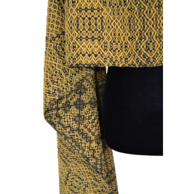 Peça de vestuário amarela com padrão geométrico preto sobre fundo preto