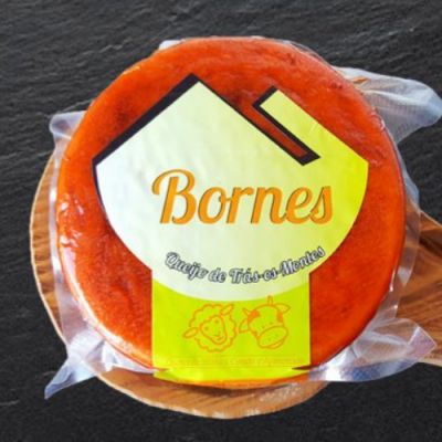 Queijo Bornes com crosta vermelha em embalagem a vácuo sobre base de madeira