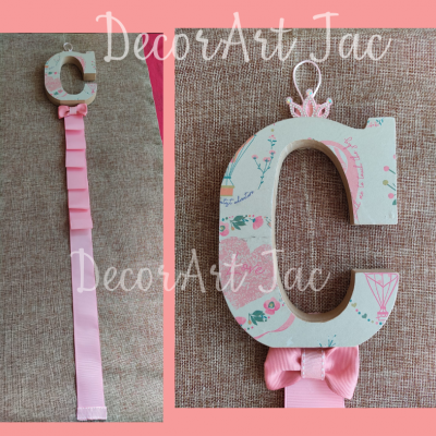 Porta-chupeta de madeira decorado com padrão floral e fita rosa