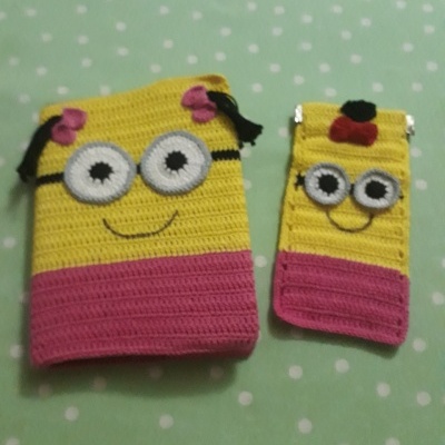 Dois porta-objetos de croché amarelo e rosa com olhos grandes e sorridentes