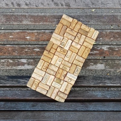 Painel rectangular feito com rolhas de vinho coladas sobre banco de madeira gasta