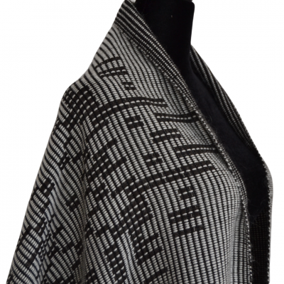 Xale ou capa cinzenta e preta com padrão geométrico em manequim preta