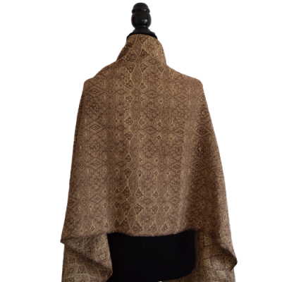 Mantão ou xale castanho com padrão geométrico sobre manequim negro