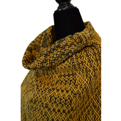 Roupa com padrão geométrico amarelo e preto com gola alta em manequim preto