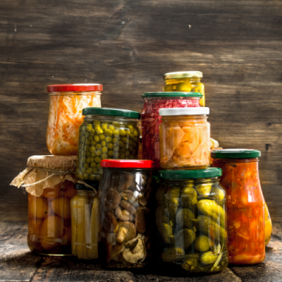 Frascos de conservas coloridas em vidro sobre superfície de madeira