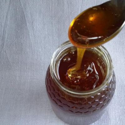 Frasco de vidro com mel e colher