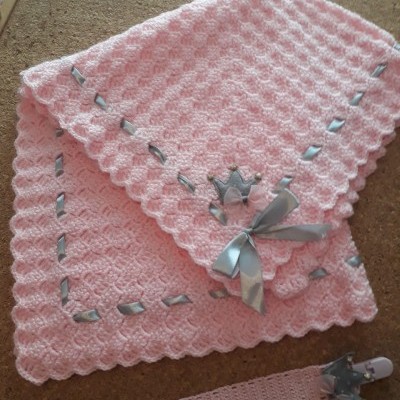 Manta de croché rosa com laço e fita cinza e chupeta com fita rosa e decoração de coroa