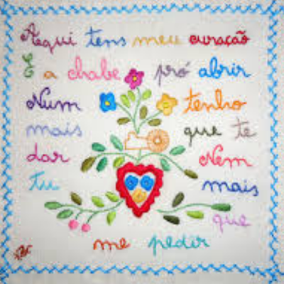 toalha bordada com texto, flores e coração colorido