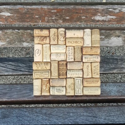 Rolhas de cortiça usadas organizadas em quadrado sobre banco de madeira