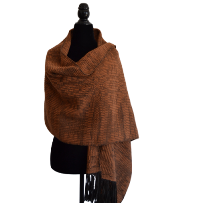 Xale castanho com padrão geométrico e franjas pretas exibido num manequim preto