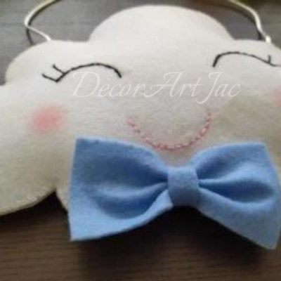 Almofada decorativa branca em forma de nuvem com rosto sorridente e laço azul