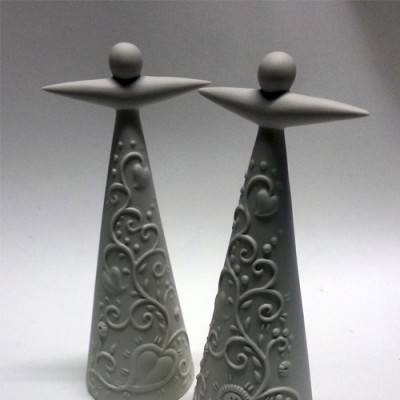 Dois objetos decorativos cinzentos em forma de cone com topo esférico e padrões em relevo.