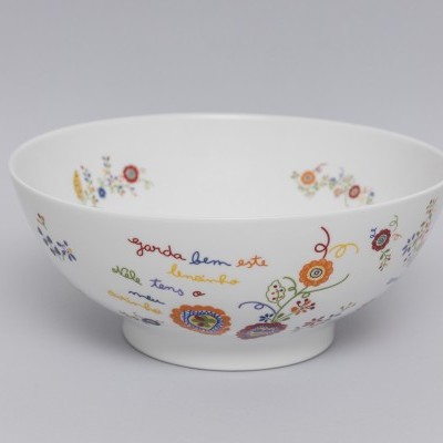 Tigela branca de porcelana com padrões florais coloridos e texto