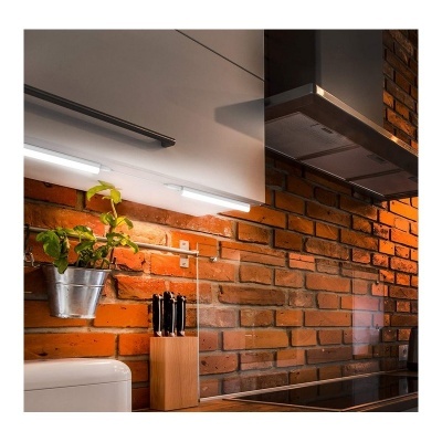 Cozinha com parede de tijolos, suporte de facas e plantas em vaso metálico