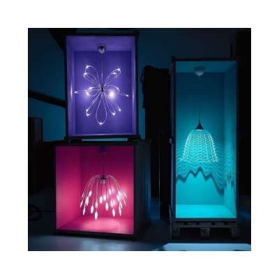 Três luminárias decorativas coloridas em caixas iluminadas