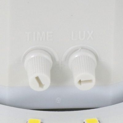 Painel branco com dois botões rotativos brancos com etiquetas TIME e LUX