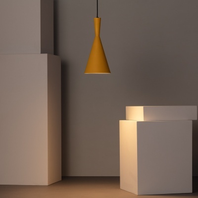 Candeeiro pendente amarelo cónico num espaço interior minimalista com pedestais brancos