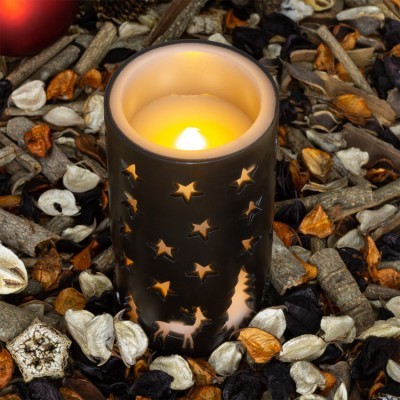 Vela decorativa com suporte cinza e recortes de estrelas e rena