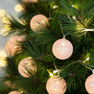 Balões de luz esféricos em pinheiro de Natal verde