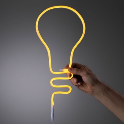 Luz LED em forma de lâmpada amarela flexível segurada por uma mão