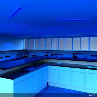 Cozinha moderna iluminada a azul com armários e bancadas e bancos altos