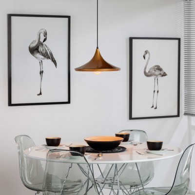 Mesa de jantar redonda branca com cadeiras transparentes, louça preta, pendente cobre e gravuras de flamingos