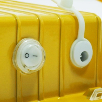 Peça amarela de equipamento elétrico com botões brancos e superfície metálica