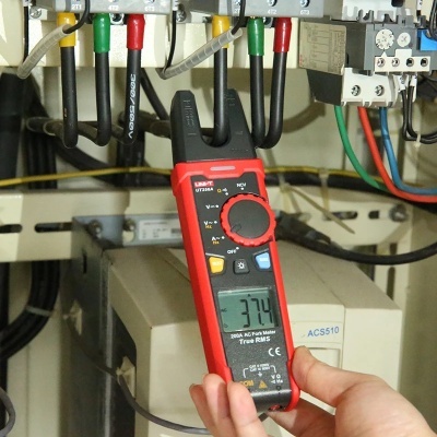 Multímetro digital preto e vermelho com display em painel elétrico colorido