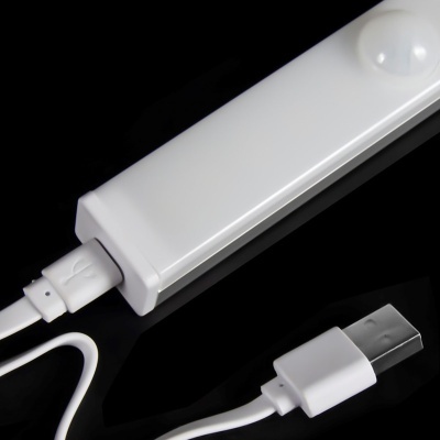 Carregador branco com cabo USB tipo A sobre superfície preta