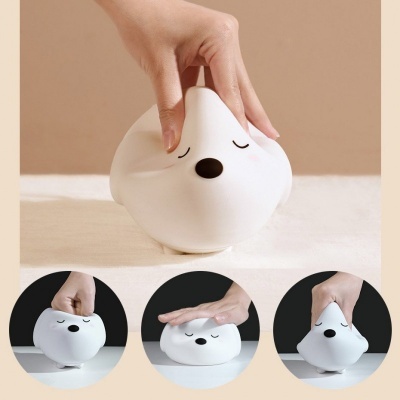 Brinquedo antistress branco maleável com rosto desenhado, sendo espremido por uma mão