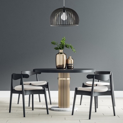 Mesa redonda preta com base dourada, quatro cadeiras pretas com assentos claros, jarras decorativas e pendente de teto negro numa sala com parede cinza