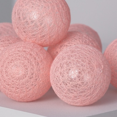 Bolinha decorativa rosa feita de fios entrelaçados